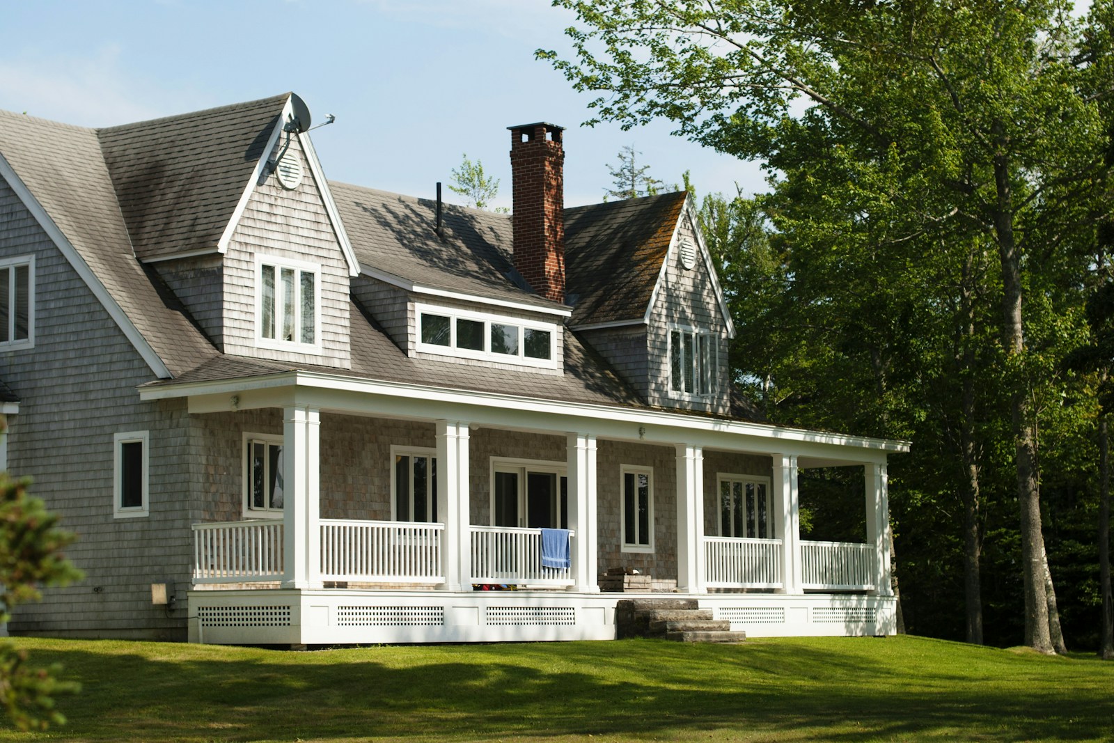 white and brown wooden house near green trees during daytime home